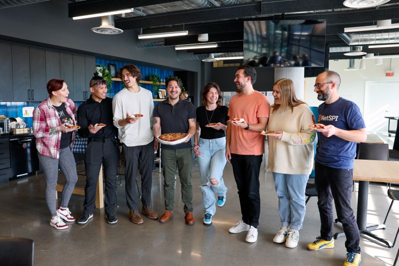 NetSPI team celebrating Pi Day with pies and a proactive security message